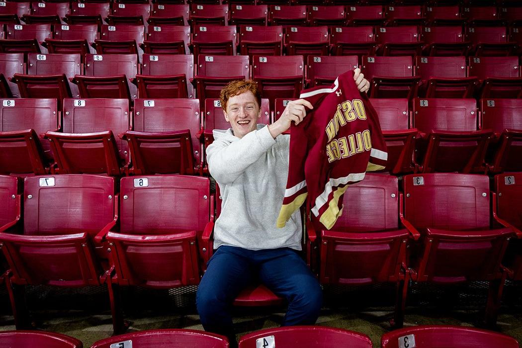 Danny Gillis waving his hockey jersey sitting in the stands